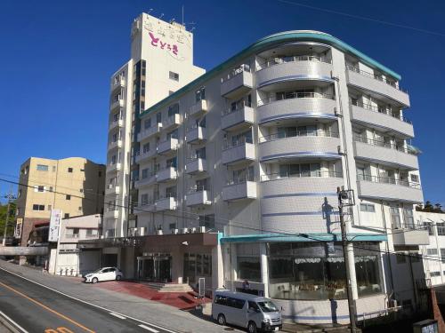 a large white building with cars parked in front of it at Ikaho Onsen Todoroki in Shibukawa