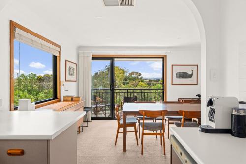 Port WillungaにあるPort of Call - Port Willunga - C21 SouthCoast Holidaysのテーブルと椅子のあるキッチンとダイニングルーム