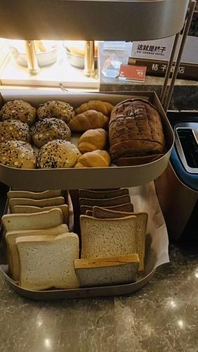 een vitrine met verschillende soorten brood en gebak bij Orange Hotel Suzhou Emerald Plaza in Suzhou