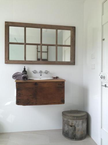 a bathroom with a sink and a mirror on the wall at Robin Hoods Well Farm Stay in Sassafras