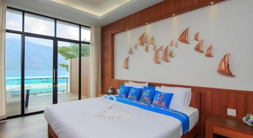 a bedroom with a large bed and a large window at The Green Hotel in Ko Lipe