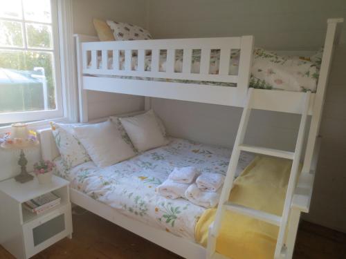 Letto a castello bianco in camera di Walnut Cottage via Leongatha a Leongatha