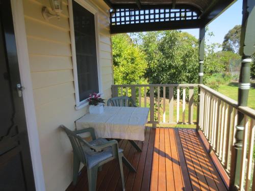a porch with a table and chairs on it at Walnut Cottage via Leongatha in Leongatha