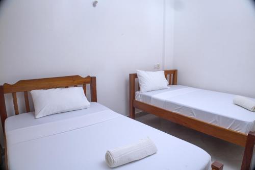 two twin beds in a room with white walls at Zuri Homes 6 B in Mombasa