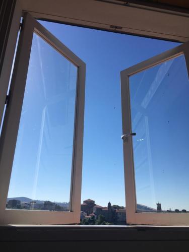 a window with a view of a blue sky at Pensión O Xardin de Julia in Santiago de Compostela