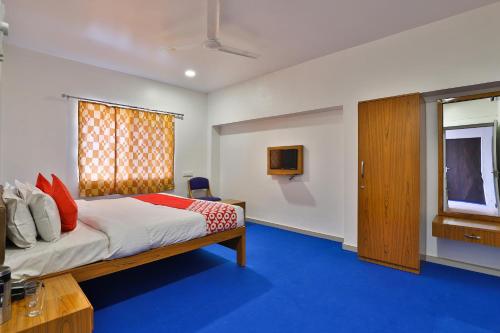 Un dormitorio con una cama y una ventana en Hotel O Milan Party Hall, en Vadodara