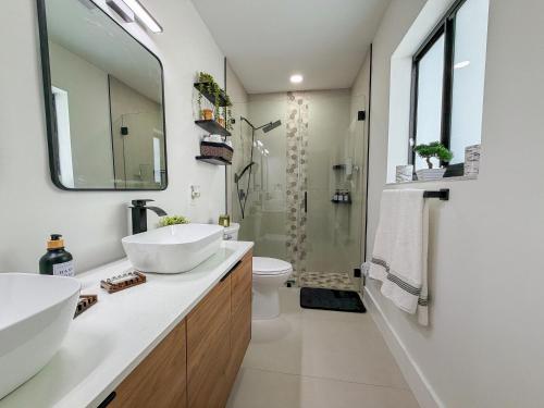 a bathroom with two sinks and a shower at King Comfort Suite Kitchen Wi-Fi Parking in Pembrook Pines