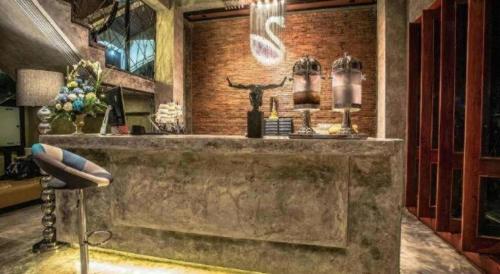 a bar in a room with a brick wall at Theloft boutique nakhonpanom in Ban Noi Pho Kham