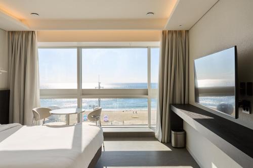 Una habitación de hotel con dos camas y vistas a la playa. en Cov Stay Haeundae, en Busan