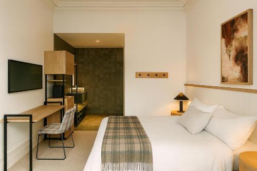 ein Hotelzimmer mit Bett und Schreibtisch in der Unterkunft Commercial Hotel Boonah in Boonah