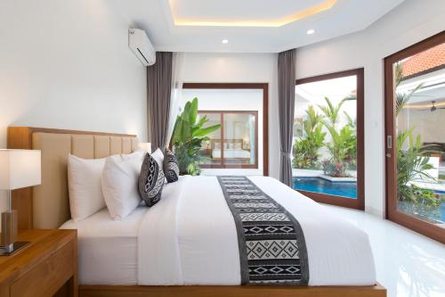 a bedroom with a white bed with a view of a pool at Villa Mia Seminyak - Boutique Villas - I in Seminyak