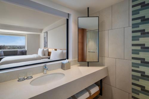 a bathroom with a sink and a large mirror at Fairfield by Marriott Jaipur Tonk Road in Jaipur