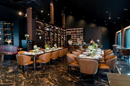 a dining room with tables and chairs and a bar at Saksiam Valley in Nonthaburi
