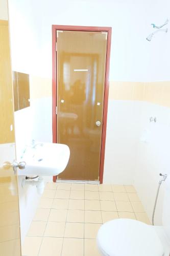 Home Sweet Home في سيمينيه: حمام مع حوض ومرحاض وباب