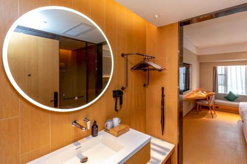 un baño con lavabo y espejo en JI Hotel Shenzhen Guangming Tianhuicheng, en Bao'an