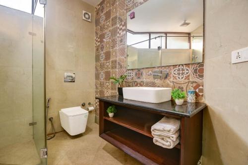 Un baño con lavabo, ducha e inodoro. en Monarch Residency Gurgaon, en Gurgaon