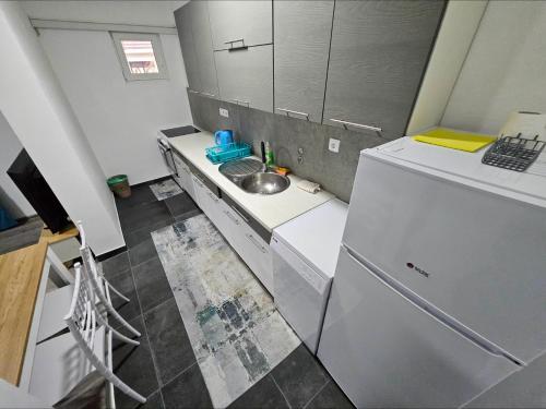 a small kitchen with a sink and a refrigerator at Apartman u centru Prnjavor in Prnjavor