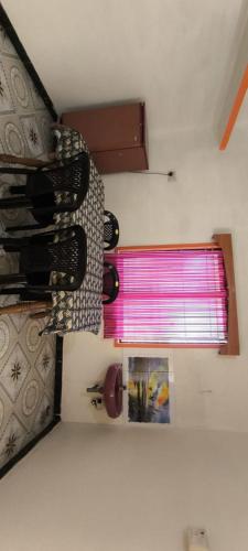 a window with a pink curtain in a room at Shevaroyen villa yercaud in Yercaud