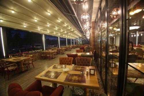 ein Restaurant mit Tischen und Stühlen und einem großen Raum in der Unterkunft The Corner Hotel in Sincan