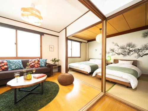 a living room with two beds and a couch at Bon Stay Matsu201 盆宿 松の間 in Takamatsu