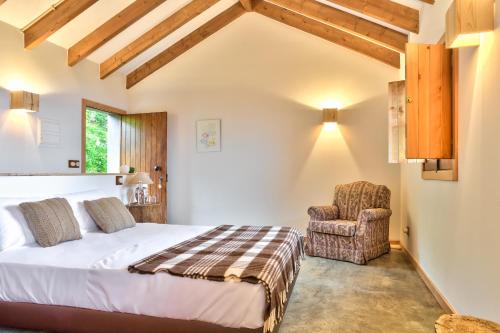 a bedroom with a bed and a chair at Casas da Levada in Ponta do Pargo