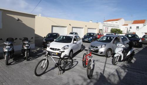 a group of cars and bikes parked in a parking lot at Hospedaria Isaias in Angra do Heroísmo