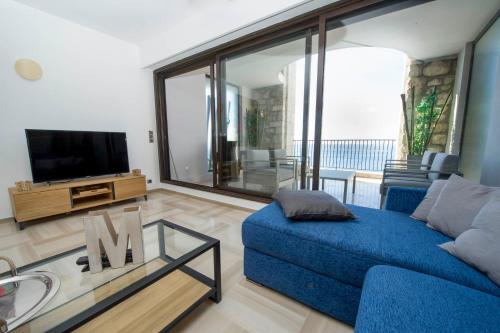a living room with a blue couch and a tv at Luxury Apartment Palais Maeterlinck in Nice