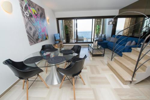 a living room with a glass table and black chairs at Luxury Apartment Palais Maeterlinck in Nice