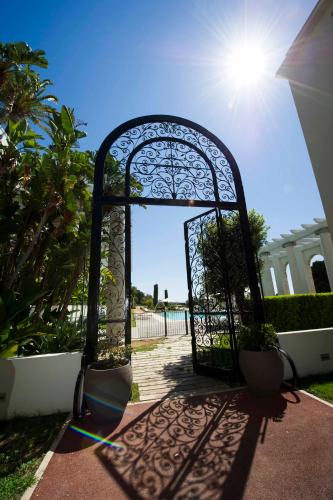 an open gate with the sun shining through it at Luxury Apartment Palais Maeterlinck in Nice