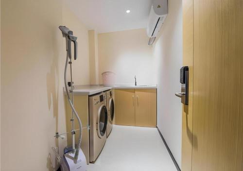 a small kitchen with a washing machine in it at City Comfort Inn Kunshan Development Zone Penglang Xinxing Middle Road in Penglang