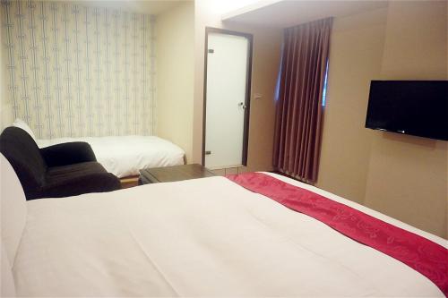 a hotel room with a bed and a tv at Every Day Hot Spring Hotel in Jiaoxi
