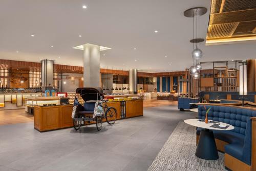 a lobby with a waiting area with chairs and tables at Four Points by Sheraton Bintan, Lagoi Bay in Lagoi