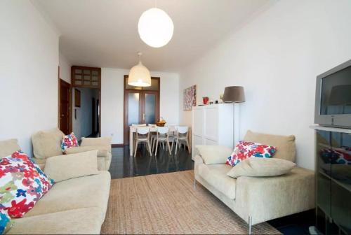 a living room with two couches and a dining room at Em frente à Praia e Marina in Vila do Conde