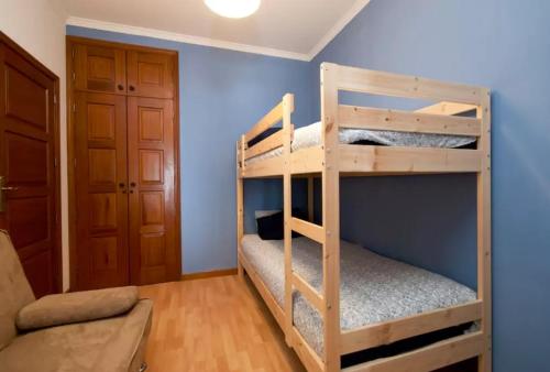 ヴィラ・ド・コンデにあるEm frente à Praia e Marinaの青い壁の客室で、二段ベッド2台が備わります。