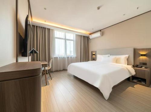 Ένα ή περισσότερα κρεβάτια σε δωμάτιο στο Hanting Hotel Shanghai Pudong Airport Nanzhu Road