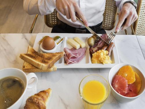 Un plato de comida de desayuno en una mesa en Novotel Paris Charles de Gaulle Airport, en Roissy-en-France