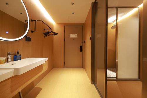 een badkamer met een wastafel en een spiegel en een douche bij Ni Hao in Houshayu