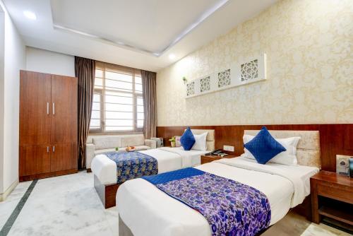 Una habitación de hotel con dos camas y un escritorio. en Monarch Residency Gurgaon, en Gurgaon