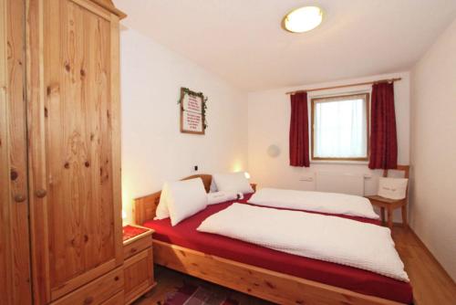 ヒパッハにあるApartment Kreidlのベッドルーム1室(ベッド1台付)、赤いカーテン付きの窓が備わります。