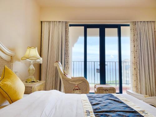 een hotelkamer met een bed en een groot raam bij baya sea view apartment in Xinshi