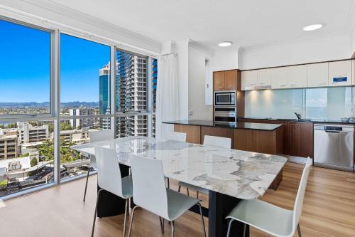 a kitchen with a table and chairs and a large window at Towers of Chevron - Private Apartments - Hosted by Coastal Letting Co. in Gold Coast
