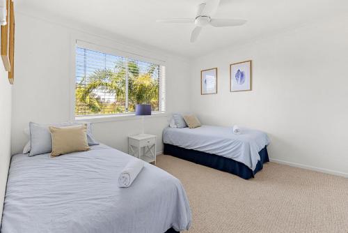 een slaapkamer met twee bedden en een raam bij Sommaroy - Pet Friendly with Fire Pit in Currarong