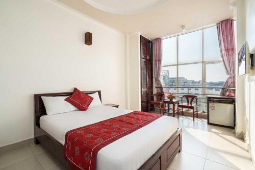 a hotel room with a bed and a large window at Collection O Dinh Dinh Hotel - Near Tan Son Nhat Airport in Ho Chi Minh City