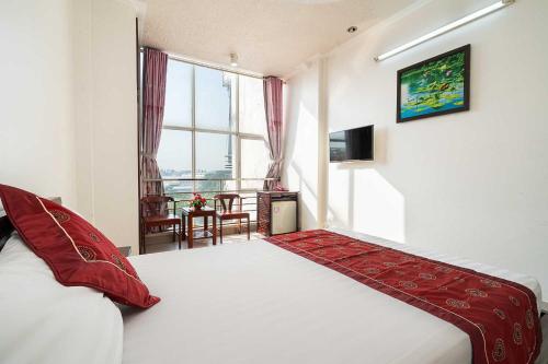 a bedroom with a bed and a large window at Collection O Dinh Dinh Hotel - Near Tan Son Nhat Airport in Ho Chi Minh City
