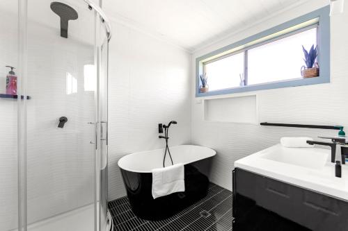 een witte badkamer met een wastafel en een douche bij Sommaroy - Pet Friendly with Fire Pit in Currarong