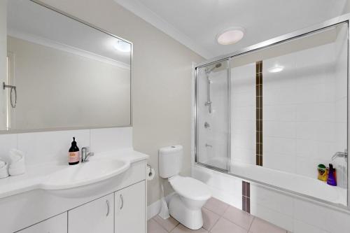 ノース・レイクスにあるMango Hill 3 Bedroom Family Accommodationのトイレと洗面台を備えた白いバスルーム