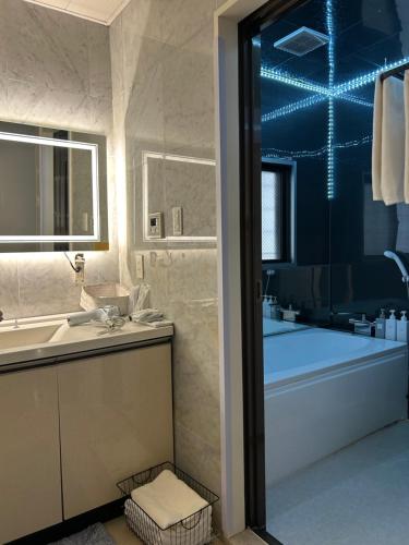 a bathroom with a tub and a sink and a bath tub at 那覇国際通り徒歩圏内Okinawa 住宅風ゲストルーム in Naha