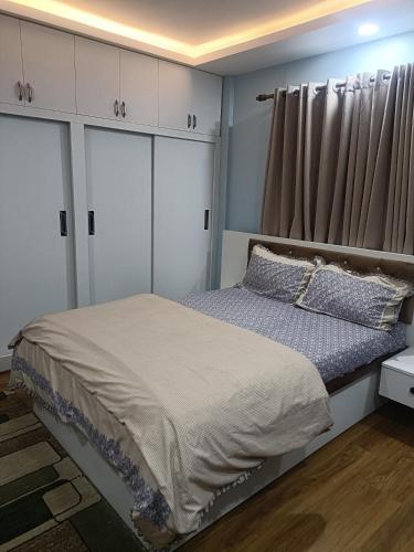 a bedroom with a bed with white cabinets and a window at Le Petit Paradis Nepal Terrace & Mountain View in Pātan
