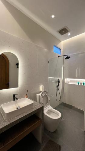 a bathroom with a toilet and a sink and a shower at Semasa Jogja Villa in Adi Sutjipto