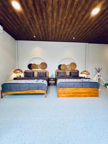 two beds in a room with wooden ceilings at Semasa Jogja Villa in Adi Sutjipto